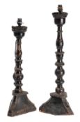 Two similar Continental ebonised wood table lamps, adapted for electricity from altar sticks,