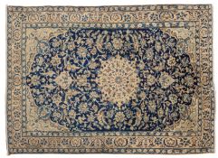 A Nain rug, the indigo cartouche field with a central beige circular medallion, all over palmette,