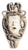 A reconstituted stone wall fountain modelled as the mask of Medusa,