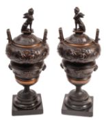 A pair of patinated metal urns and covers in Neoclassical taste,