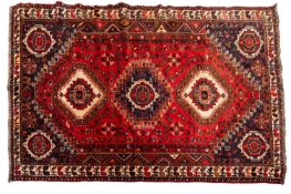 A Qashgai carpet, the red hexagonal field with triple stepped octagonal ivory and indigo medallions,