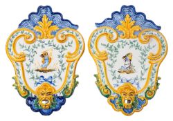 Four Italian majolica plaques of shield shaped form with shell cresting and basal grotesque mask