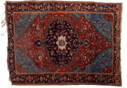 A Sarouk rug, the brick red lozenge field with a central indigo cartouche pole medallion,