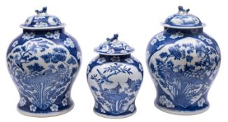 A garniture of three Chinese blue and white 'magpie and prunus' vases and covers,