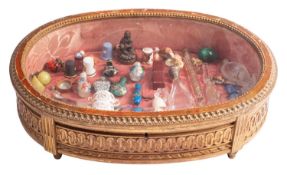 A carved giltwood and glazed table-top bijouterie case and contents, the case in Louis XVI taste,