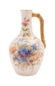 A Royal Worcester porcelain ewer with faux bamboo handle decorated with wild flowers,