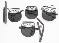 A group of four black leather Pipe band sporrens.