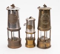 A collection of three miner's lamps. Including two Protector Lamp & Lighting Co. Ltd.