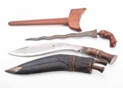 An early 20th century kris, of traditional form in a wooden scabbard, blade length 31cm,