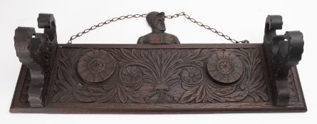 An early 20th century carved oak wall hanging riding crop stand,