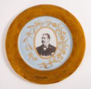 A portrait of a Victorian gentleman set within a ceramic plate.