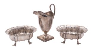 An Edwardian pair of silver bonbon dishes, of shaped oval outline and on four scroll legs,