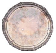 A Victorian small silver salver, of shaped circular outline, with a bead & foliate scroll border,