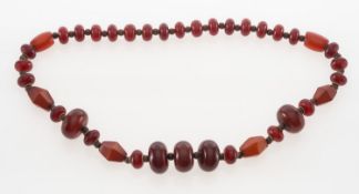 A cherry Bakelite amber style bead necklace with wooden and yellow metal spacers.