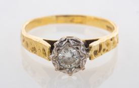 A diamond solitaire ring, illusion set with a brilliant-cut diamond, hammered finish band,