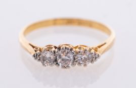 A diamond three stone ring, with three round transitional cut diamonds,