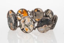 A dendritic agate bracelet with oval transparent agate panels with a dendritic display in orange