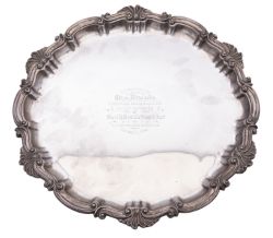 A Victorian silver salver, of shaped circular outline, with a husk and scroll border,