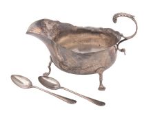 An Edwardian silver sauce boat, oval form, with a wavy rim and a leaf-capped scroll handle,