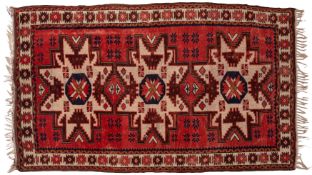 A Turkish rug, the brick red field with