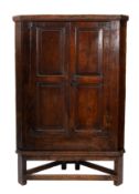 A George III oak corner cabinet on later