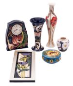 Six pieces of John Moorcroft pottery comprising a clock in the Queens Choice pattern,