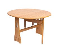 A blonde elm drop leaf dining table by Ercol, mid 20th Century.