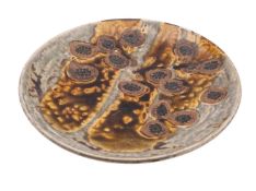 A contemporary Japanese stoneware charger decorated with stylised mottled blooms,