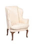 An upholstered wing armchair in Queen Anne style,