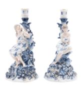 A pair of German porcelain figural candlesticks each with a classically draped maiden seated before