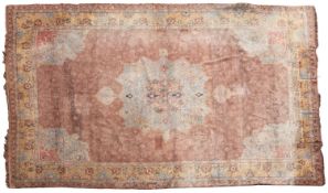 A Turkish carpet, the plum field with a central pastel blue and pink shaped pole medallion,