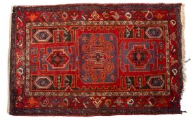 An Afghan Belouch rug, the wine field with geometric medallions,