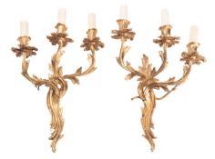 A pair of gilt metal three-light wall appliques in Louis XV style,