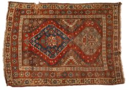 A Caucasian rug, the rust field with stepped and pointed medallions,