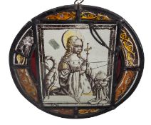 A Flemish or Dutch stained and leaded glass roundel depicting a female Saint kneeling in prayer,