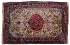 An Indo Persian rug, the ivory field with a central wine cartouche pole medallion,