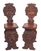 A pair of Italian carved walnut hall chairs, in 17th century style,
