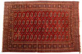 A Turkoman carpet, the tomato red field with four rows of quartered guls,