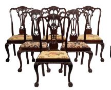 A set of twelve carved and stained hardwood dining chairs in George III style,