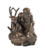 A Chinese polished bronze figure of a seated Immortal with a stag, 17cm.