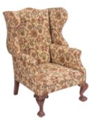 An upholstered wing armchair in George II style,