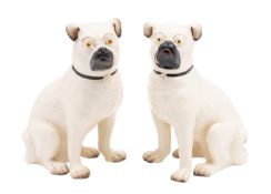 A pair of glazed pottery models of pugs, modelled seated and with painted facial features,