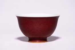 A CHINESE OXBLOOD-GLAZED BOWL WITH FLARED RIM AND FOOTED BASE.