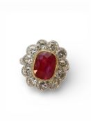 A Fine Antique 6 carat Burma Ruby, the faceted ovoid stone set as a ring in white gold with diamonds
