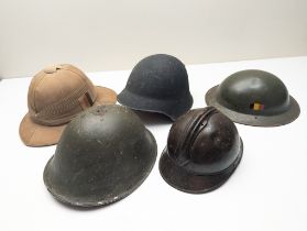 Five Military Helmets, to include one Wolseley Pattern Tropical Pith Helmet with Insignia
