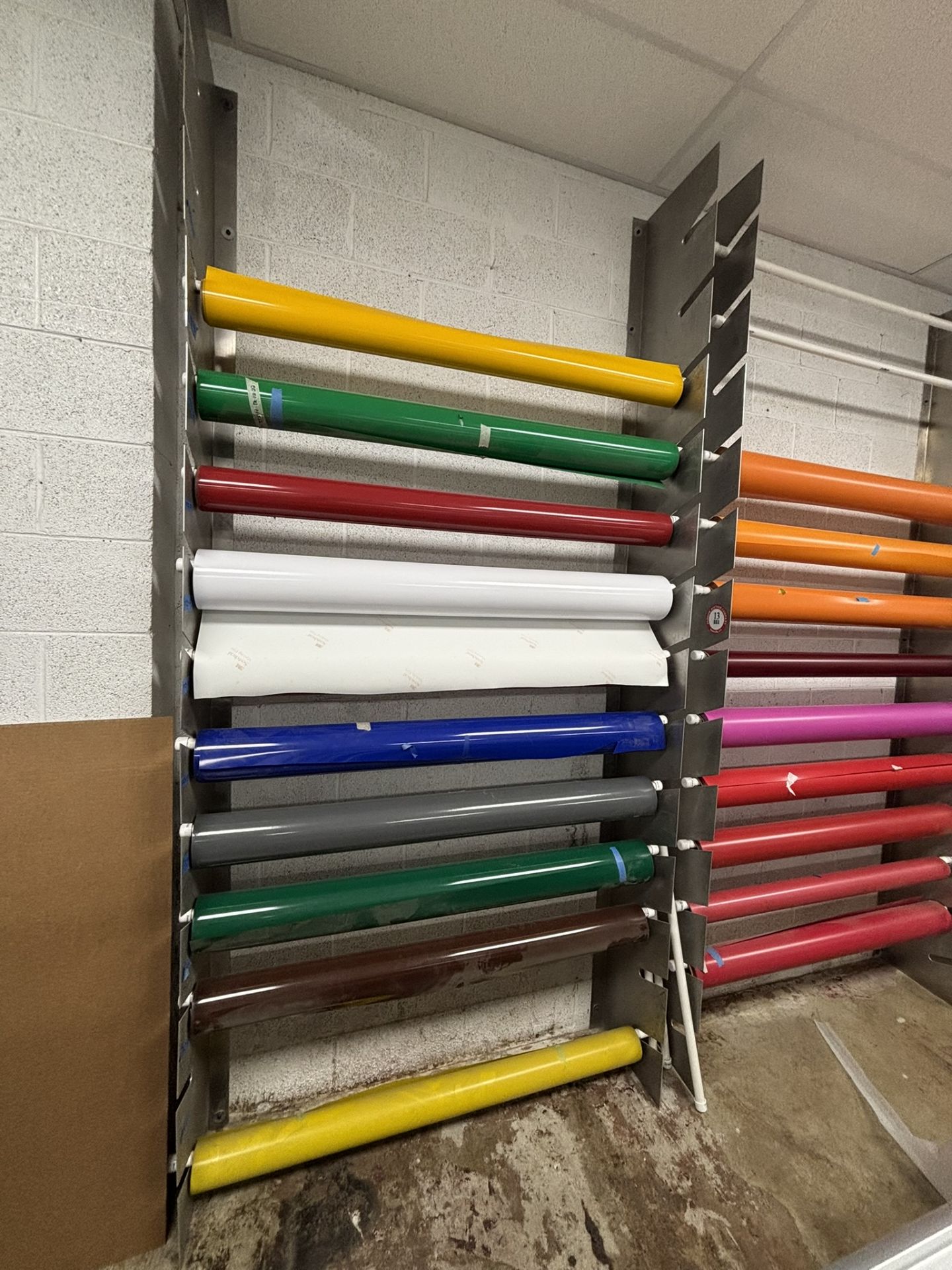 Approximately 9 Partial Rolls of 4' Vinyl, Assorted Colors, Plus Rolled Vinyl Storage Rack