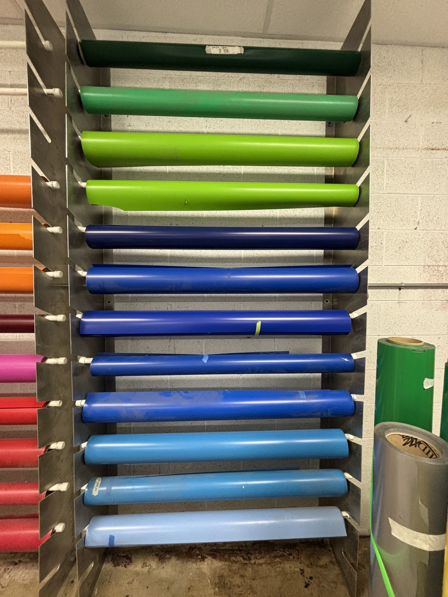 Approximately 11 Partial Rolls of 4' Vinyl, Assorted Colors, Plus Rolled Vinyl Storage Rack