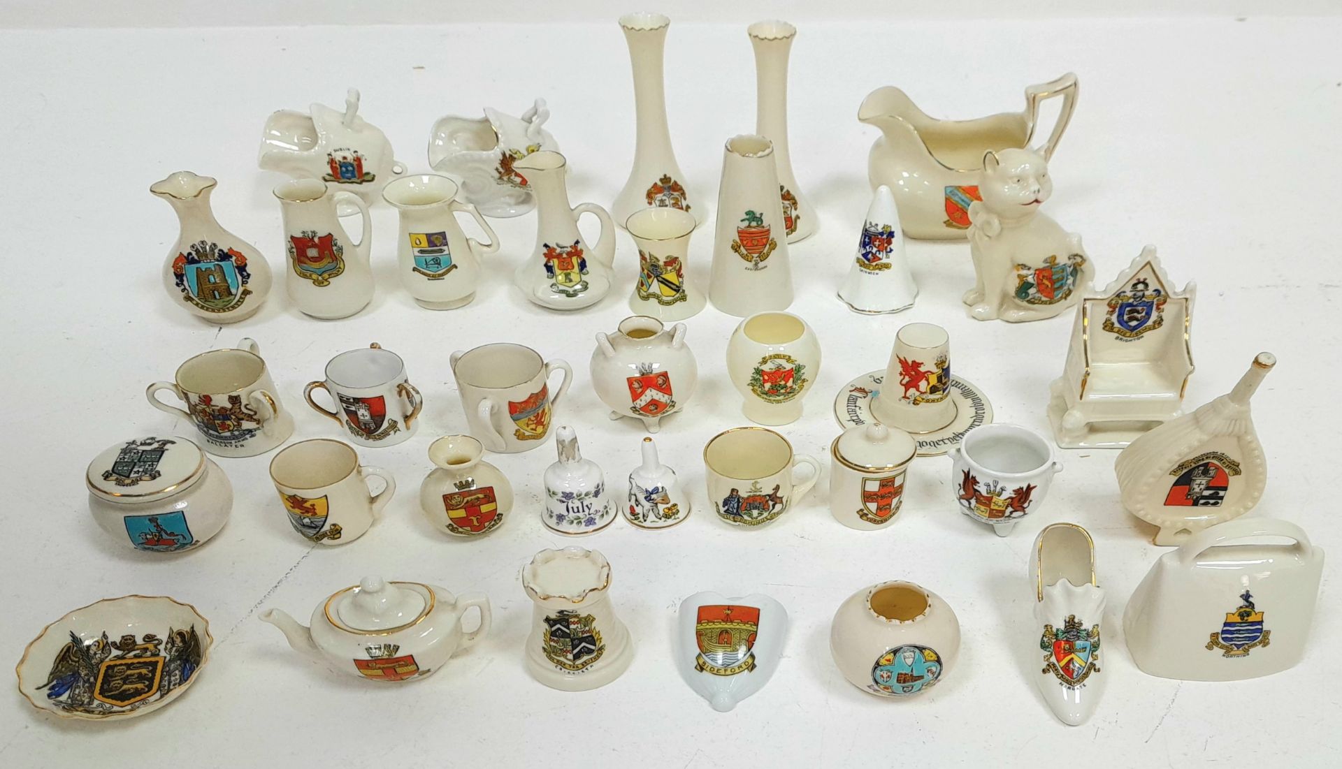 A large mixed collection of decorative ceramic crested ware items.