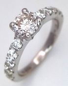 AN 18K WHITE GOLD, DIAMOND SET, SOLITAIRE RING WITH DIAMOND SET SHOULDERS. 1.50 CT WEIGHT. CENTRE