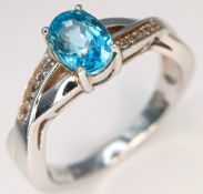 A Stylish Sterling Silver Blue and White Topaz Crossover Style Ring Size N1/2. The Ring is set